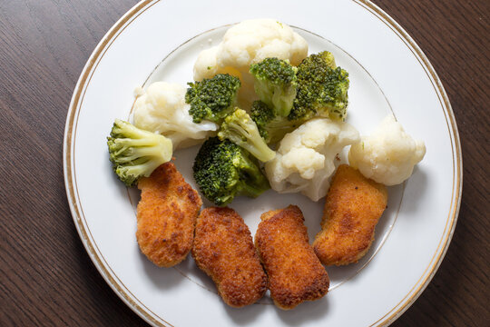 Dinner on a white plate that is on a dark background