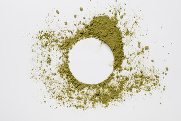 Circle made of green powder scattered on a white background, with a place for text. Copy space. Bright dry paint. Top view. 