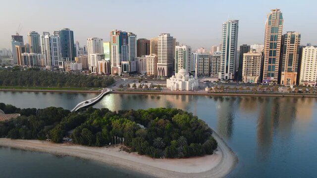 Sharjah aerial view above Al Noor island and mosque and downtown rising above Khalid lake