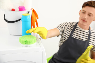 Handsome man with cleaning sponge in bathroom