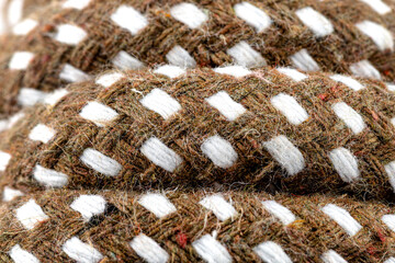 Macro photo of a brown rope with white details made of cotton and jute.