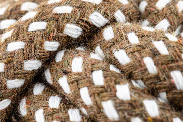 Macro photo of a brown rope with white details made of cotton and jute.