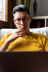 Close-up of serious young man using his laptop. Concept of teleworking.