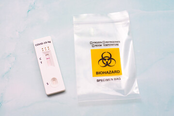 A covid-19 antigen test is discarded in a biohazard bio-waste bag
