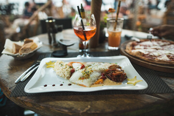 Grilled fish on a table in the restaurant and some alcohol drinks.