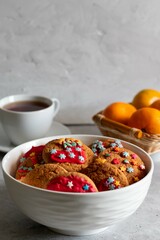 Christmas cookies, tangerines and a white cup of tea on a light background