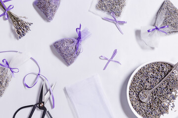 Fototapeta na wymiar Lavender sachets home and wardrobe fragrance freshener, natural anti-repellent, transparent package with dried flowers, on white silk tablecloth. Herbal medicine concept.