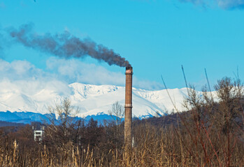 The furnace of a power plant. Snow-capped mountains in the background. Coal-based energy - concept.