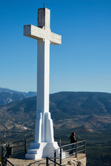 Large white stone cross on the hill of Santa Catalina in Jaén (Spain) and its views over mountains of crops