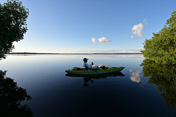 Active senior kayaking on Coot Bay in Everglades National Park, Florida on clear calm sunny winter afternoon.