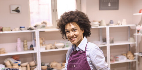 Portrait of smiling beautiful creative woman , pottery artist. Looking at camera. Artist at ceramic studio. 