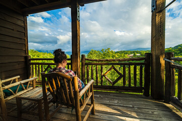 Woman rests in wooden chair on porch with beautiful view of the Great Smoky Mountains - obrazy, fototapety, plakaty