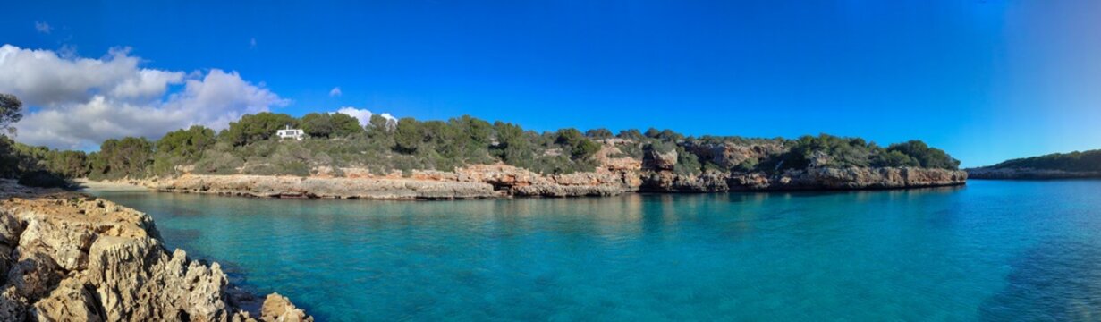 Panoramic photo of Cala  Sa Nau beach in Mallorca. Beautiful view of the seacoast of Mallorca with an amazing turquoise sea, in the middle of the nature. Concept of summer, travel, relax and enjoy.