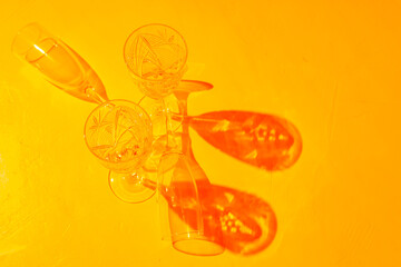 Empty champagne glasses with shadows on an orange background. Glassware in the sunset light. Minimalism. Copy space