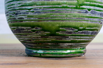 Green ceramic background with stripes. A detail of old vase.