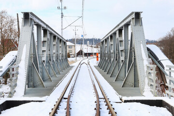 TRUTE, POLAND - NOVEMBER 30, 2021: Iron railway bridge under the snow. - obrazy, fototapety, plakaty