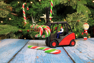 Sweet candy canes being carried by a scale model forklift truck ready to be hung on a Christmas tree.
