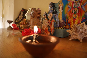 single diya with a background of Hindu gods Diwali
