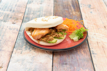 fried salmon gao bao with crispy onion, ripe avocado, sesame seeds and grated carrot