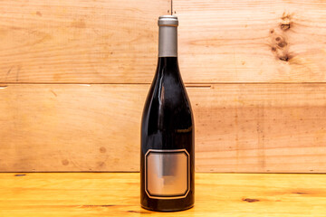 Cava or champagne bottle on wooden table with unvarnished wooden background