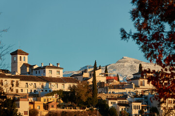 Obraz premium View of the Albaicin neighborhood of Granada (Granada) at sunset with the snow-capped peaks of Sierra Nevada in the background