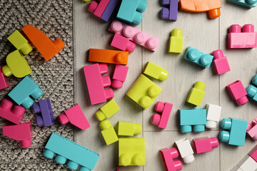 Fototapeta premium Colorful plastic building blocks on floor, flat lay