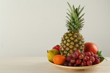 Fresh ripe fruits on white wooden table, space for text