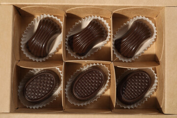 Many delicious chocolate candies in box, top view. Production line