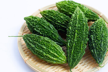 Bitter gourd in bamboo basket on white background.