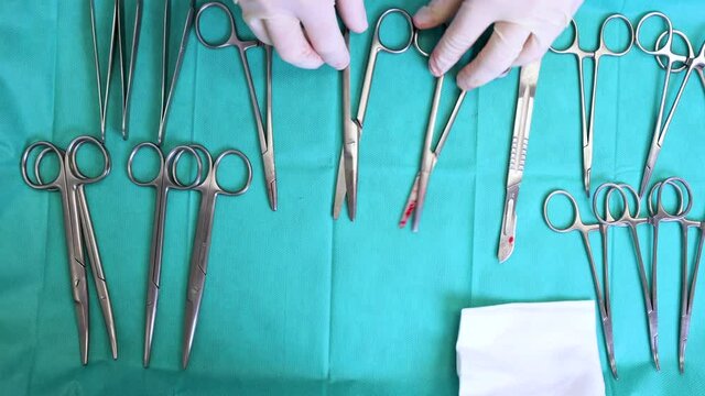 Multiple surgery instruments on blue table above view. surgeon take surgical tools from table. High quality 4k footage