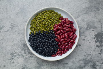 Assortment of beans mung bean, red kidney bean , black bean in bowl on concrete background