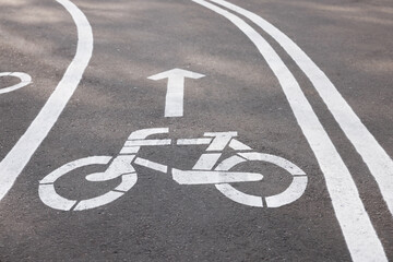 Obraz premium Bicycle lane with sign and arrow pointing direction on asphalt
