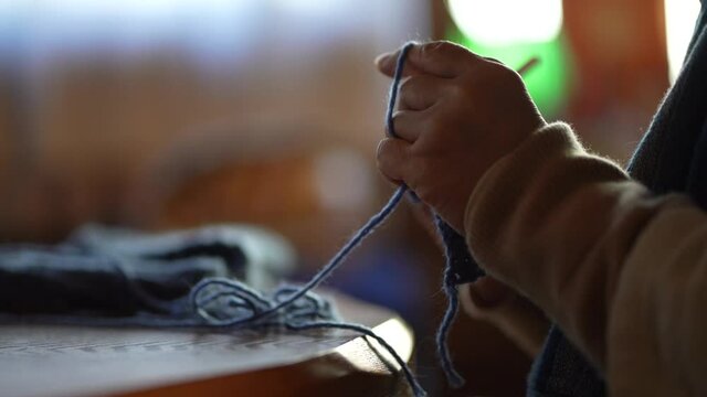 ネックウォーマーを手編みする女性の手元