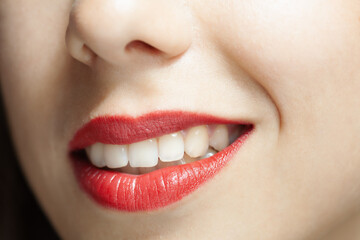 Close up abstract portrait of a beautiful caucasian girl. Winking face expression. Smiling lips with white teeth.