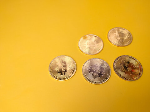 Bitcoins on a yellow background with copy space.