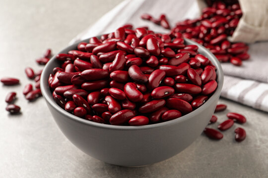 Raw red kidney beans in bowl on light grey table, closeup