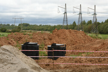 A black septic tanks halfway buried in dirt outside