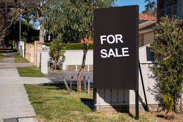 For sale sign on black board near the resedential building. Real estate concept