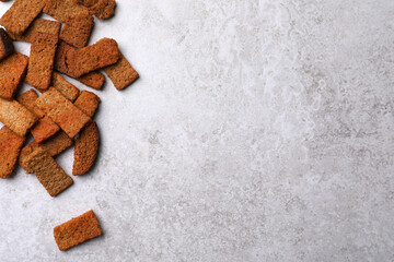 Heap of crispy rusks on light table, flat lay. Space for text