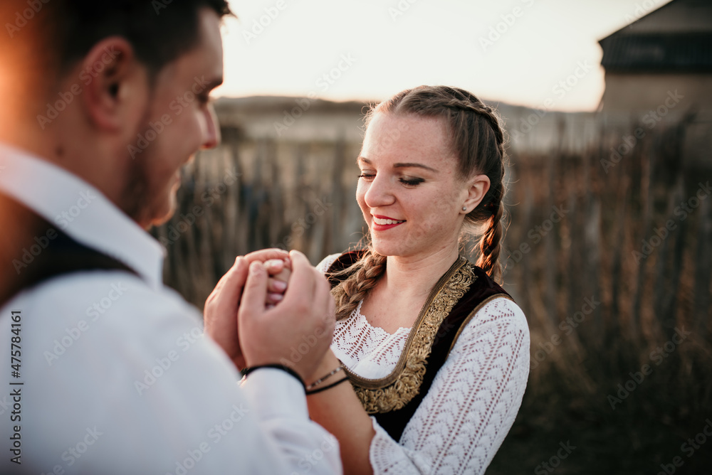 Canvas Prints Close-up shot of a young happy beautiful couple in traditional Serbian costumes holding hands