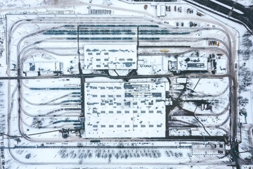 tram depot in winter foggy day. urban industrial district with snow-covered buildings. aerial overhead view.