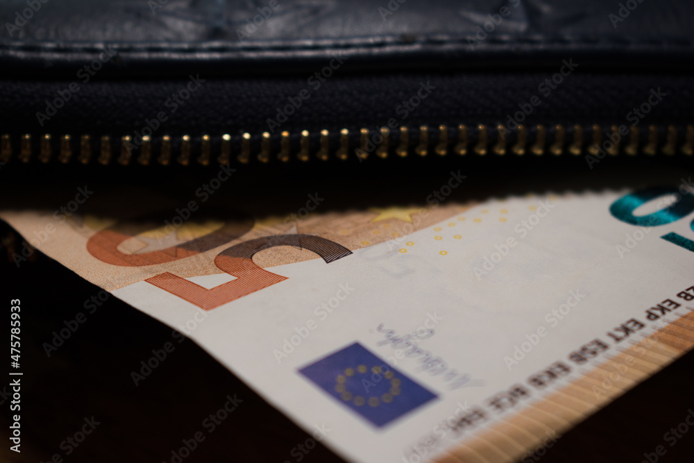 Wall mural Closeup of a black wallet and euros