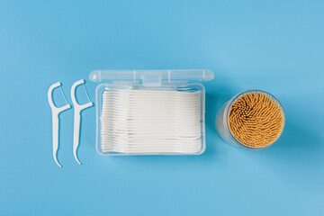 toothpicks and dental floss on blue background.