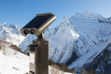 Binoculars on the observation deck in the high, snowy mountains.