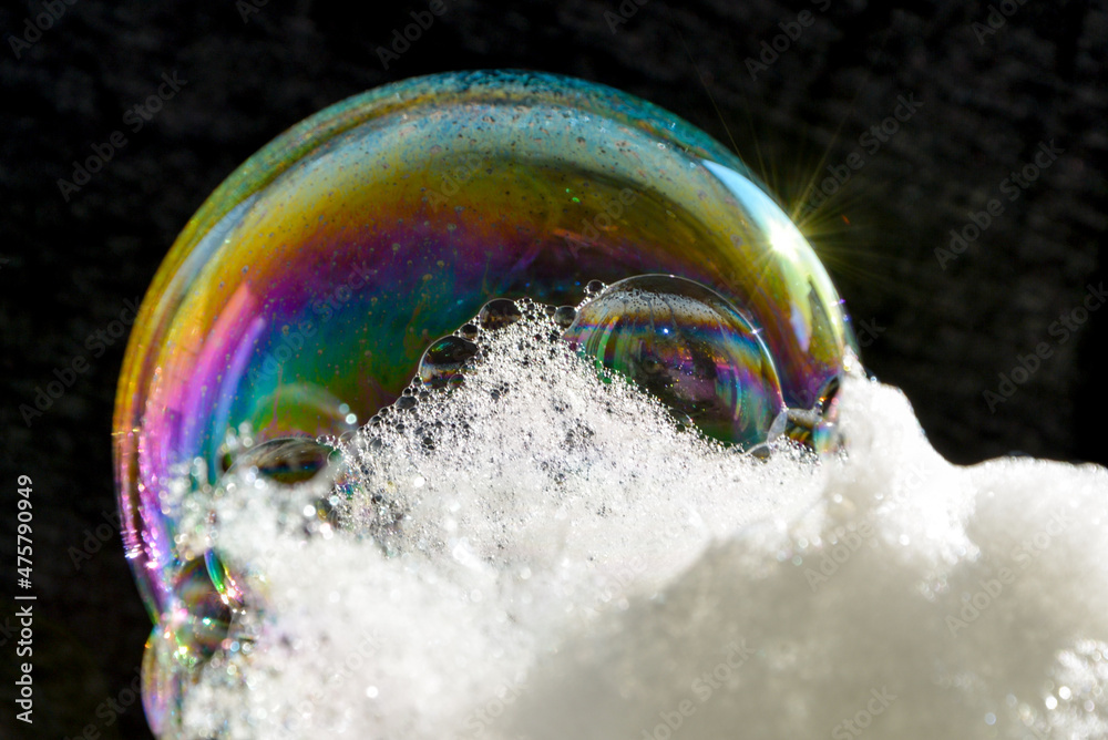 Poster Magical soap bubble with iridescent colors on a black background