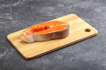 Raw salmon steak over board