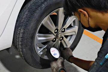 mechanic checking pressure tire