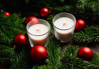 Lighted candle in the green pine branches. Christmas background. Selective focus.