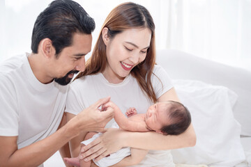 Happy family with newborn child. Newly father and mother excited having first baby, family holding and smiling to their baby.