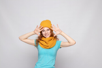 red-haired girl in a warm hat on a light background